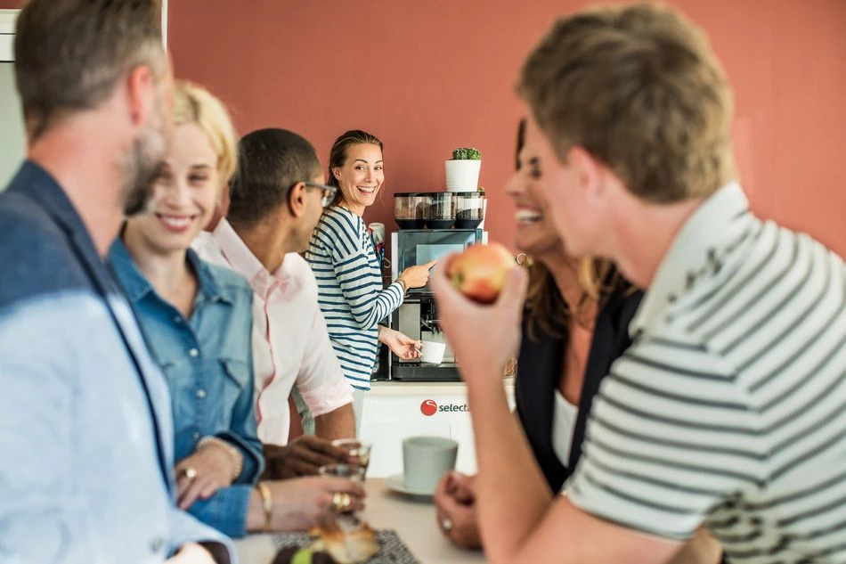 office-coffee-break A group of people enjoying office coffee made with a tabletop coffee machine